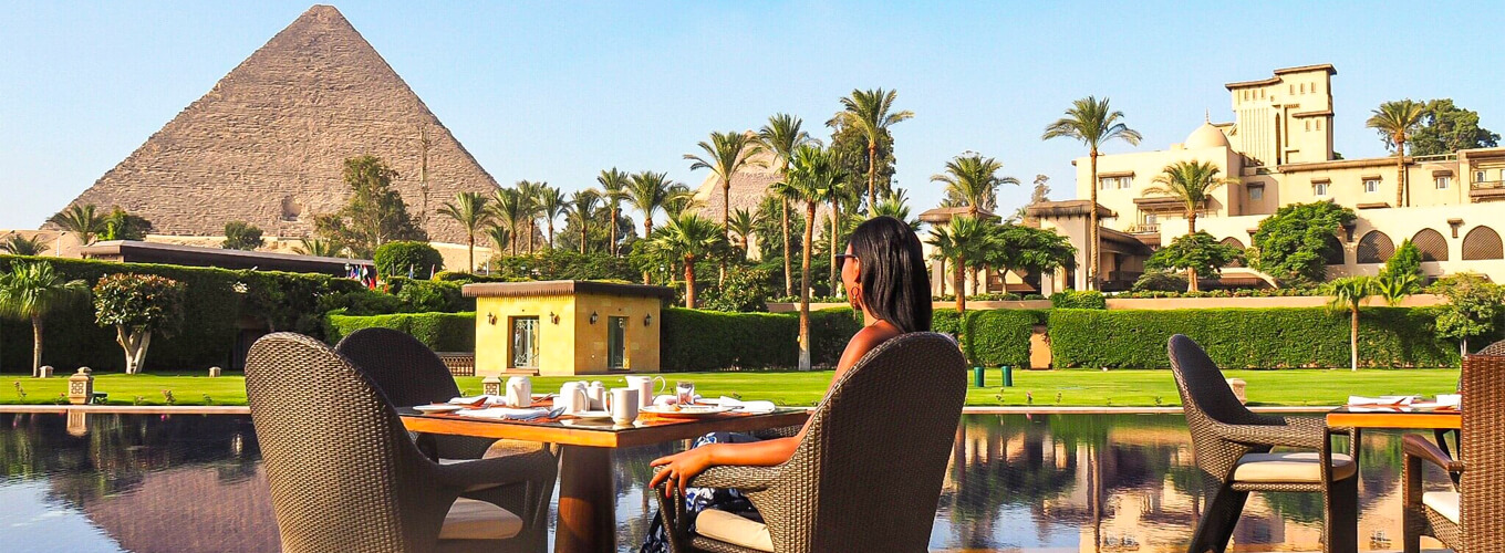 A-wonderful-photo-of-a-tourist-sitting-in-a-restaurant-in-front-of-the-pyramids
